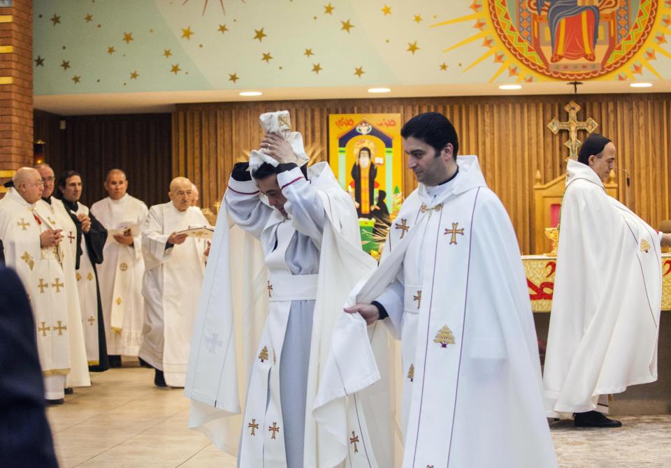 Deacon Wissam Akiki, who is married, center left, is ordained into the priesthood during a ceremony at St. Raymond’s Maronite Cathedral Thursday, Feb. 27, 2014, in St. Louis. Akiki is the first married priest to be ordained by the Maronite Catholic Church in the United States in nearly a century. (AP Photo/Erin Stubblefield)