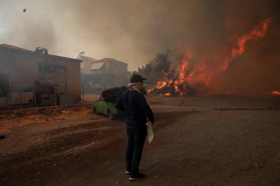 <p>El incendio ha arrasado varias casas de Vatera entre la angustia de sus vecinos. Algunos huían y otros trataban de proteger sus viviendas. (Foto: Elias Marcou / Reuters).</p> 