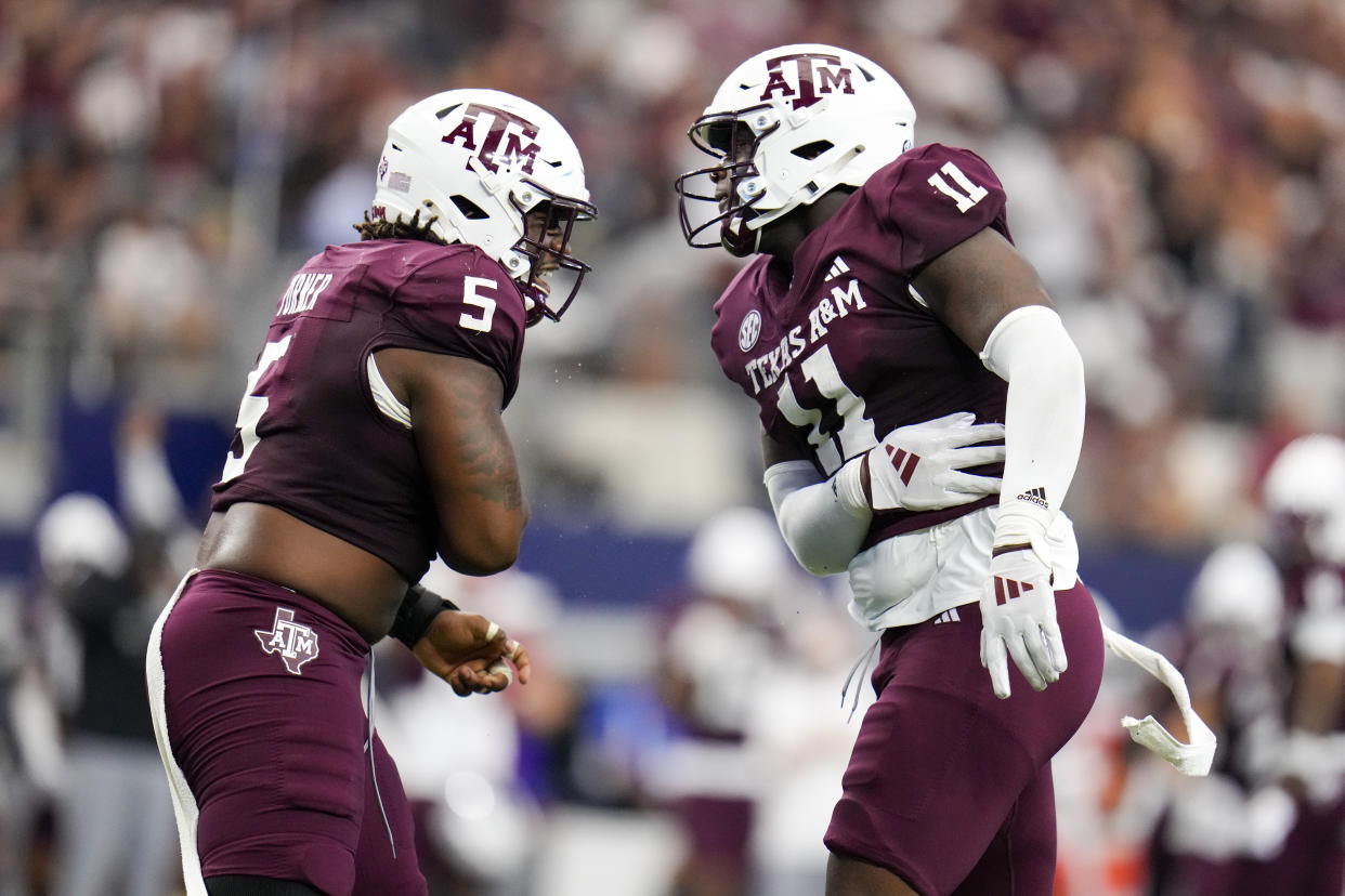 Texas A&M defensive lineman Shemar Turner, left, and defensive lineman Nic Scourton react after a tackle during the first half of an NCAA college football game against Arkansas, Saturday, Sept. 28, 2024, in Arlington, Texas. (AP Photo/Julio Cortez)