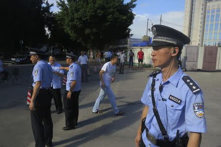 Police officers stand guard outside the court house, blocking roads to the Guangzhou People's Court in the southern Chinese city of Guangzhou September 12, 2014. REUTERS/James Pomfret