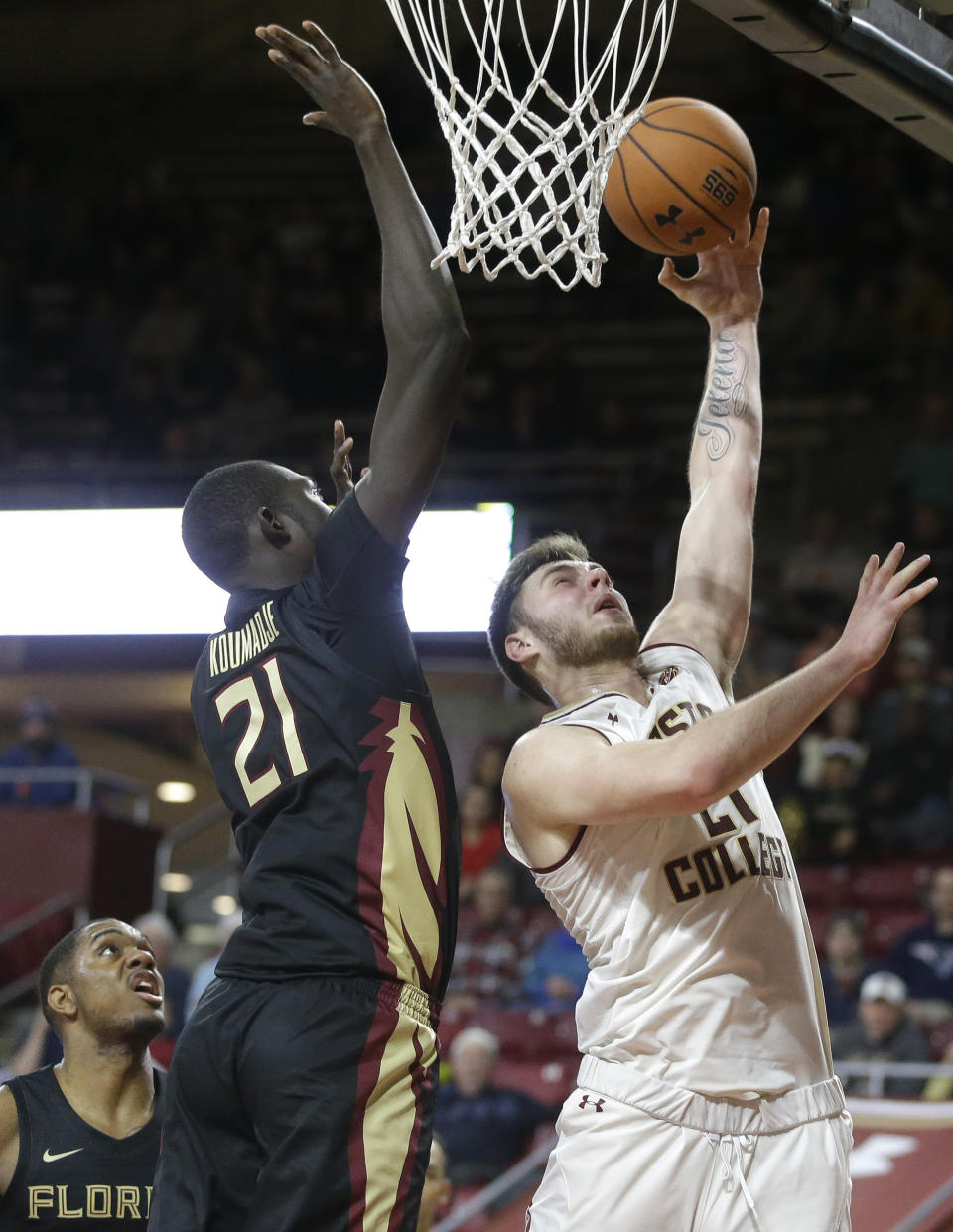 Boston College forward Nik Popovic, right, drives toward the basket past Florida State's Christ Koumadje, center left, in the second half of an NCAA college basketball game, Sunday, Jan. 20, 2019, in Boston. (AP Photo/Steven Senne)