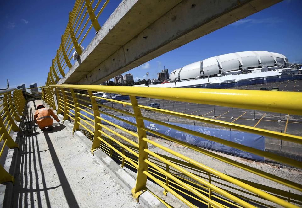 A construction worker lays concrete on a bridge next to the Dunas arena soccer stadium in Natal, June 12 , 2014. Mexico will face Cameroon in their 2014 World Cup football match here on June 13. REUTERS/Dylan Martinez