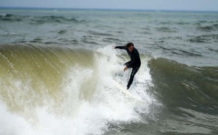 A surfer rides a wave after Hurricane Arthur in Kitty Hawk, North Carolina July 4, 2014. REUTERS/Chris Keane