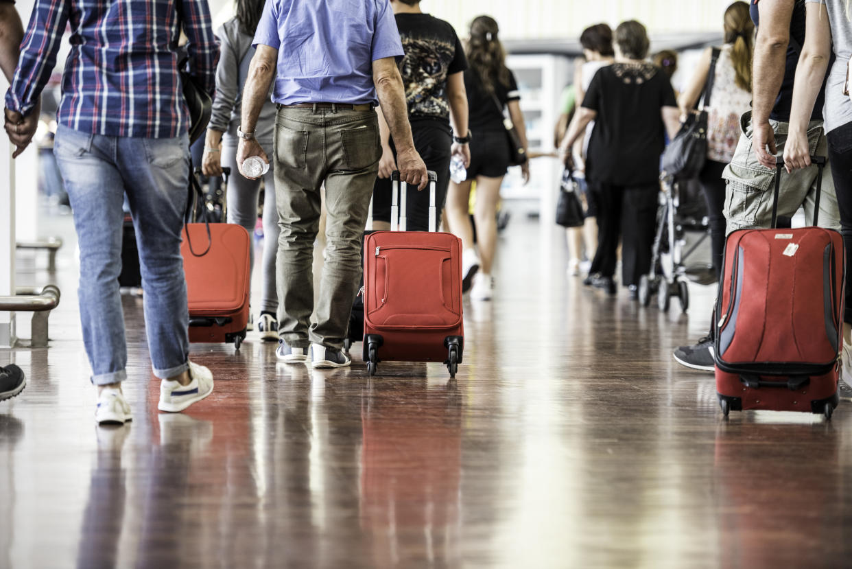 Travelers with suitcases walking through the airport