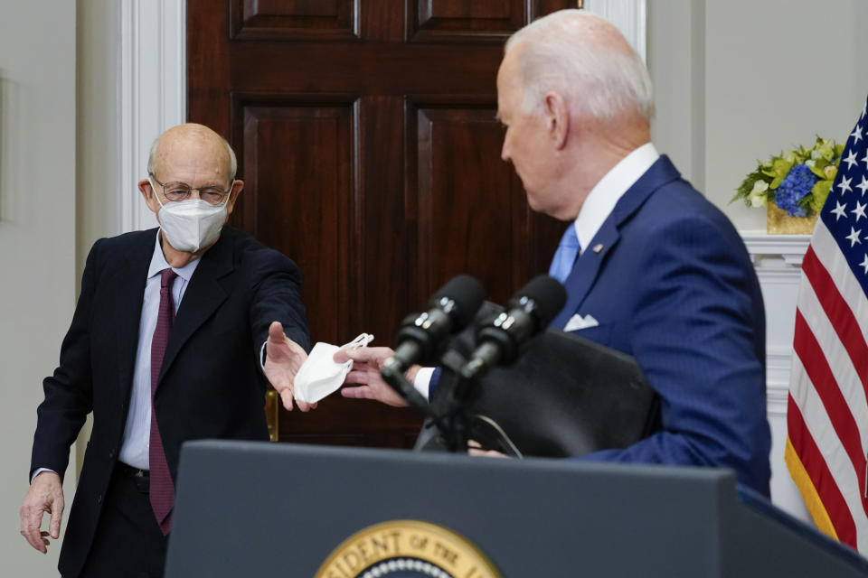 President Joe Biden hands Supreme Court Associate Justice Stephen Breyer a face mask after Breyer announced his retirement in the Roosevelt Room of the White House in Washington, Thursday, Jan. 27, 2022. (AP Photo/Andrew Harnik)