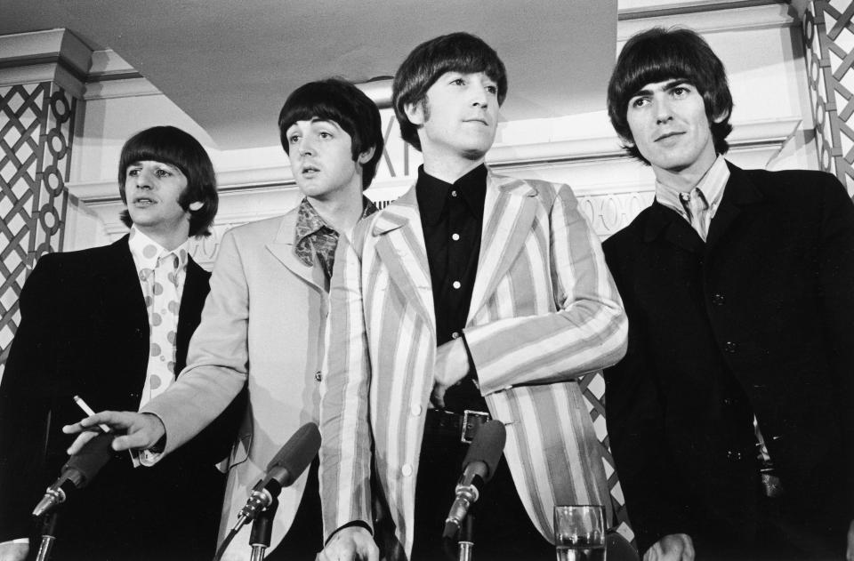 1966:  British pop group the Beatles standing in front of four microphones at a press conference where they discussed their concert at Shea Stadium, New York City. L-R: Ringo Starr, Paul McCartney, John Lennon (1940 -1980), and George Harrison (1943 - 2001).  (Photo by Santi Visalli Inc./Getty Images)