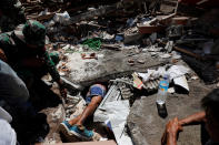 <p>A volunteer crawls beneath rubble while soldiers try to find survivors at a collapsed house after earthquake hit on Sunday in Pemenang, Lombok Island, Indonesia, Aug. 7, 2018. (Photo: Beawiharta/Reuters) </p>