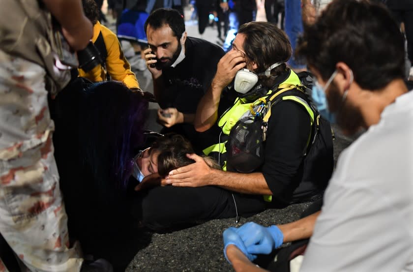 Paramedics treat a protester who was run over by a car on Sunset Boulevard on Thursday night.