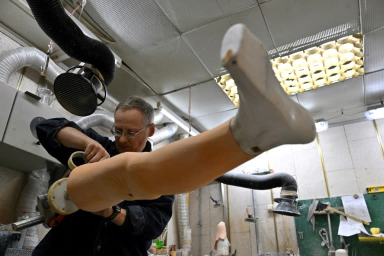 Un employé travaille sur une prothèse de jambe dans une clinique orthopédique, le 25 mai 2022 à Kiev, en Ukraine (AFP/Sergei SUPINSKY)