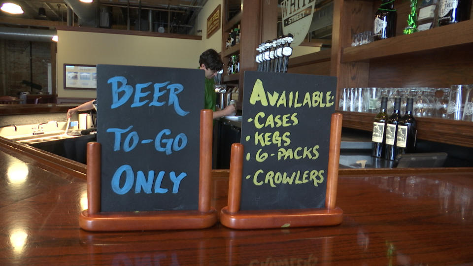 An employee at White Street Brewing Company in Wake Forest, N.C., fills a "crowler" can of beer on Tuesday, March 17, 2020. With bars ordered close due to coronavirus, brewers are making sure their customers can enjoy some fresh suds. (AP Photo/Allen G. Breed)