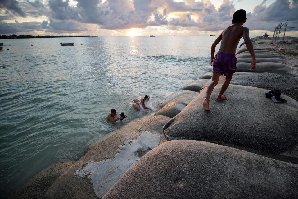 Boys play in the lagoon on sandbags reinforcing a land reclamation project, a countermeasure to the rising sea, on November 24, 2019 in Funafuti, Tuvalu.