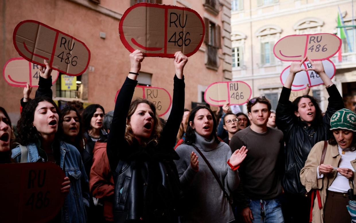 Women hold cardboards cutouts of RU-486 (abortion pill mifepristone) as they demonstrate outside Madama Palace (Senate)
