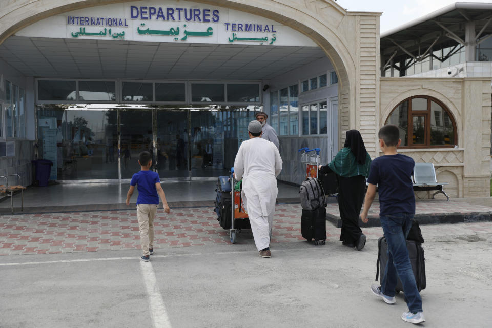 Passengers enter the departures terminal of Hamid Karzai International Airport, in Kabul, Afghanistan, Saturday, Aug. 14, 2021. As a Taliban offensive encircles the Afghan capital, there's increasingly only one way out for those fleeing the war, and only one way in for U.S. troops sent to protect American diplomats still on the ground: the airport. (AP Photo/Rahmat Gul)