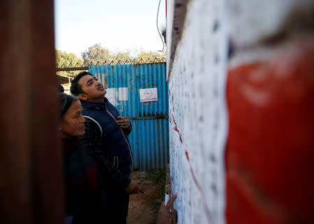 People search for their names on the voters list outside a polling station during the parliamentary and provincial elections in Bhaktapur, Nepal December 7, 2017. REUTERS/Navesh Chitrakar