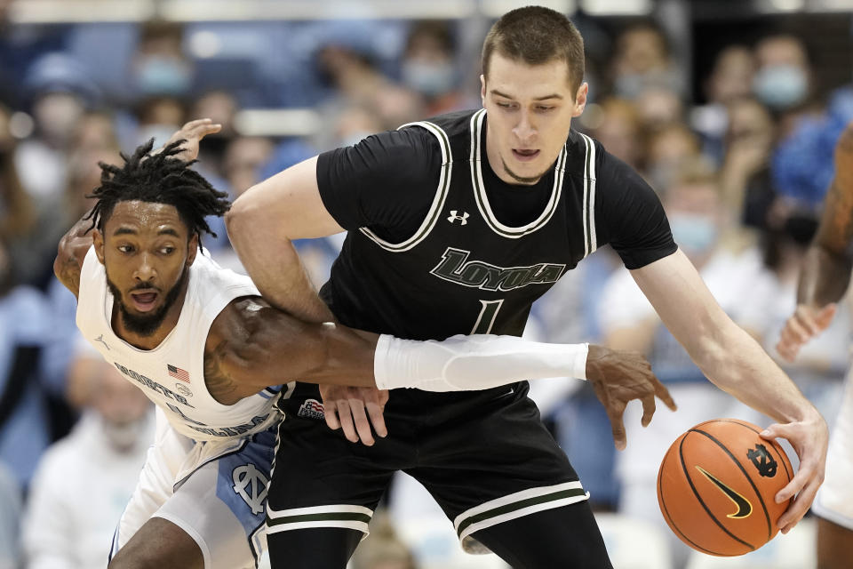 North Carolina guard Leaky Black, left, reaches for the ball against Loyola Maryland forward Veljko Ilic (1) during the first half of an NCAA college basketball game in Chapel Hill, N.C., Tuesday, Nov. 9, 2021. (AP Photo/Gerry Broome)