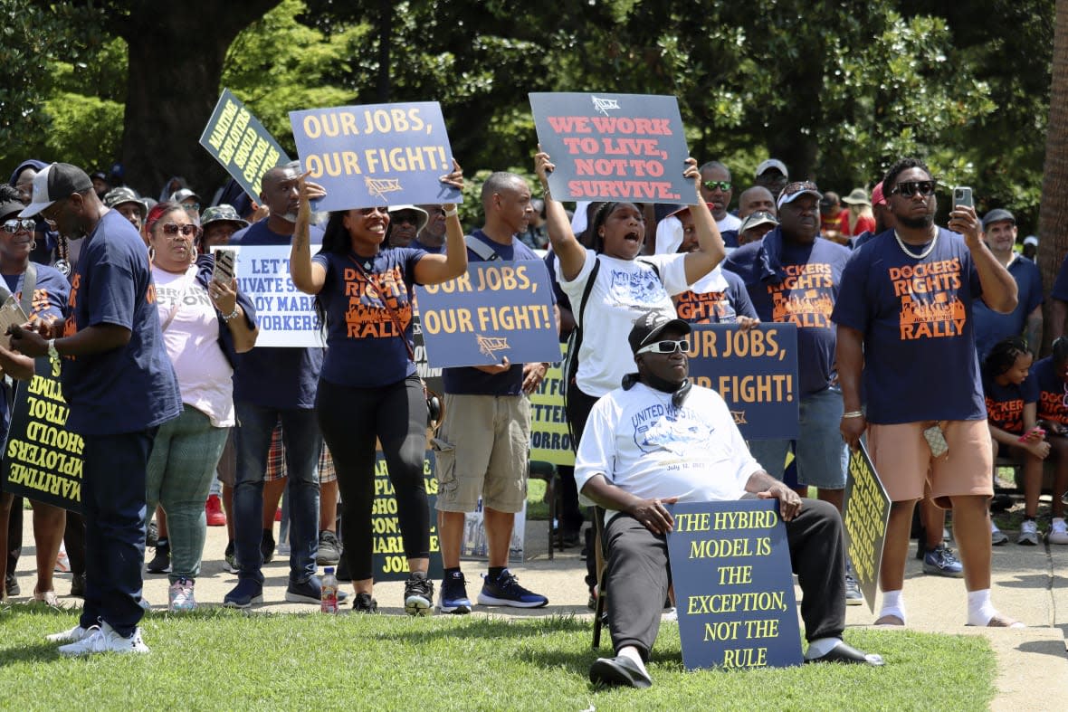 Workers hold signs supporting labor organizers in their legal battle over container loading jobs at a rally in Columbia, S.C. on Wednesday, July 12, 2023. (AP Photo/James Pollard)