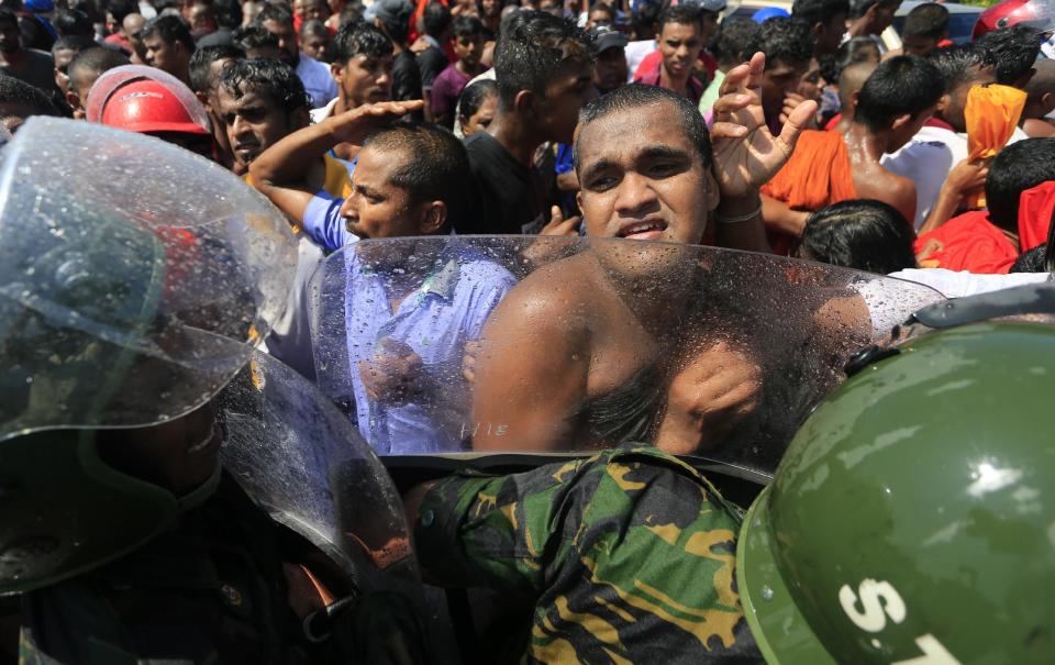 A Sri Lankan Buddhist monk and villagers clash with police officers during a protest outside the inauguration ceremony of an industrial zone in Mirijjawila village in Ambalantota, Sri Lanka, Saturday, Jan. 7, 2017. Sri Lankan police used water cannons to try to break up violent clashes Saturday between government supporters and villagers marching against what they say is a plan to take over private land for an industrial zone in which China will have a major stake. The government has signed a framework agreement for a 99-year lease of the Hambantota port with a company in which China will have 80-percent ownership. Officials also plan to set up the nearby industrial zone where Chinese companies will be invited to set up factories. (AP Photo/Eranga Jayawardena)