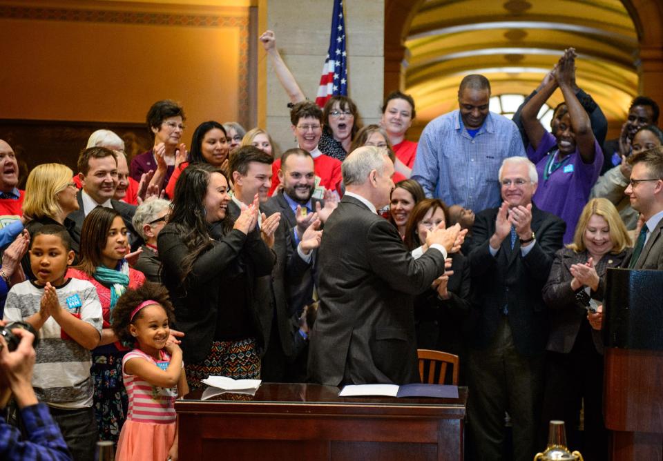 The crowd cheers after Governor Mark Dayton signed the minimum wage bill into law at a public bill signing ceremony Monday, April 14, 2014 at the Minnesota State Capitol Rotunda in St. Paul. Minnesota goes from having one of the nation's lowest minimums to among the highest. With federal wage legislation stuck in Congress, states are rushing to fill the void. (AP Photo/The Star Tribune, Glen Stubbe) MANDATORY CREDIT; ST. PAUL PIONEER PRESS OUT; MAGS OUT; TWIN CITIES TV OUT