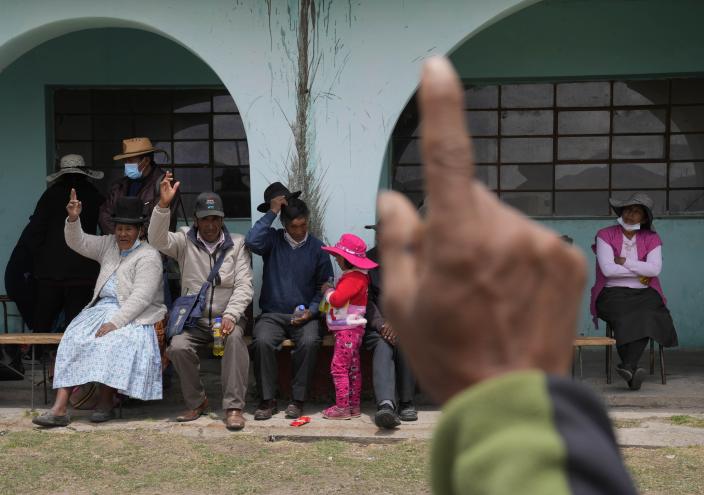 Indigenous residents who have not been vaccinated for COVID-19 raise their hands during a community meeting to discuss if they will get the Sinopharm vaccine for COVID-19, during a vaccine campaign set up at a local school in Mijane, Peru, Thursday, Oct. 28, 2021. While more than 55% of Peruvians have gotten at least one shot of COVID-19 vaccines, only about 25% of people in Indigenous areas have been vaccinated. (AP Photo/Martin Mejia)