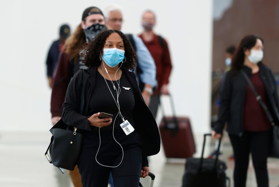 Passengers, most wearing face masks, enter the main terminal after arriving at Denver International Airport on April 23, 2020.