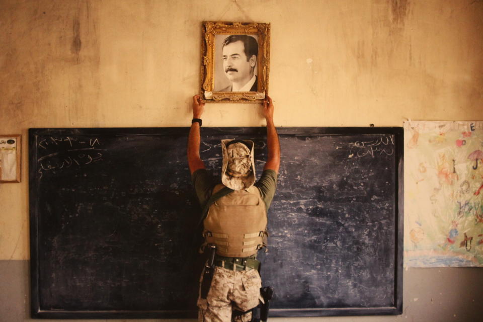 <p>A U.S. Marine pulls down a picture of Saddam Hussein at a school April 16, 2003 in Al-Kut, Iraq. A combination team of Marines, Army and Special Forces went to schools and other facilities in Al-Kut looking for weapons caches and unexploded bombs in preparation for removing and neutralizing them. </p>