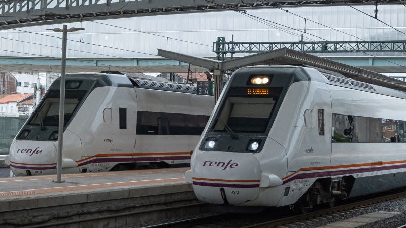 A photo of two trains at a station in Spain. 