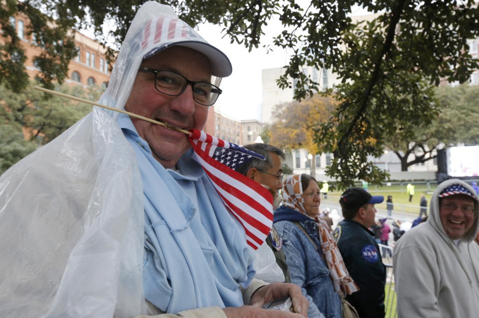 A spectator from Vermont holds a U.S. flag as crowds gather in Dealey Plaza prior to 50th anniversary ceremonies of JFK's assassination in Dallas