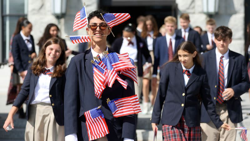 Logan Costa carries an abundance of American flags while leaving the Constitution Month kickoff event at the Capitol in Salt Lake City on Thursday, Aug. 31, 2023. Gary Herbert spoke at the event.