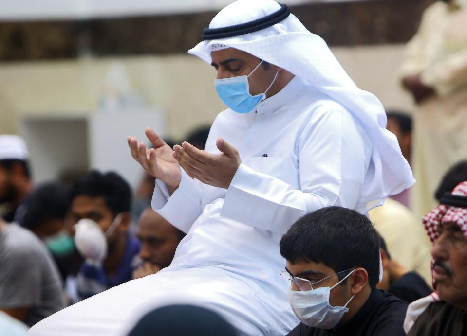 Muslim men wearing protective masks perform Friday prayers at a mosque in Kuwait City on February 28, 2020. - Kuwait's Ministry of Awqaf and Islamic Affairs set the Friday prayer sermon to not exceed 10 minutes, and to discuss precautions against COVID-19 coronavirus disease infections. Kuwait has recorded 43 coronavirus cases since its outbreak, the United Arab Emirates reported 13, while Bahrain has 33, and Oman is at four cases. Government institutions in the gulf country suspended the use of fingerprint recognition to clock in and out. (Photo by YASSER AL-ZAYYAT / AFP) (Photo by YASSER AL-ZAYYAT/AFP via Getty Images)