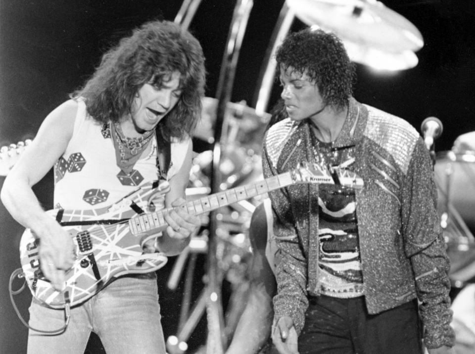 FILE - This July 14, 1984 file photo shows Van Halen guitarist Eddie Van Halen, left, performing "Beat It" with Michael Jackson during Jackson's Victory Tour concert in Irving, Texas. Van Halen, who had battled cancer, died Tuesday, Oct. 6, 2020. He was 65. (AP Photo/Carlos Osorio, File)