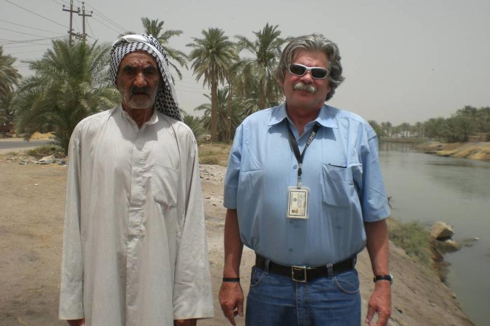 Sun-Star Executive Editor Mike Tharp and Naji Habeeb, 85, an Iraqi rice farmer, stand next to a channel of the Euphrates River near his paddies in southern Iraq.