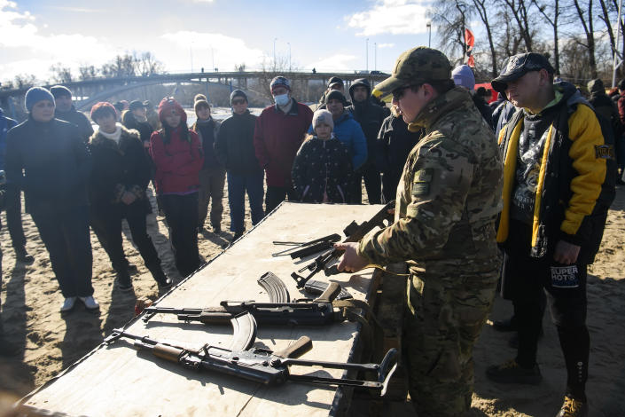 Kyiv citizens stand near a table with weapons on it as they take part in a military training for civilians. 