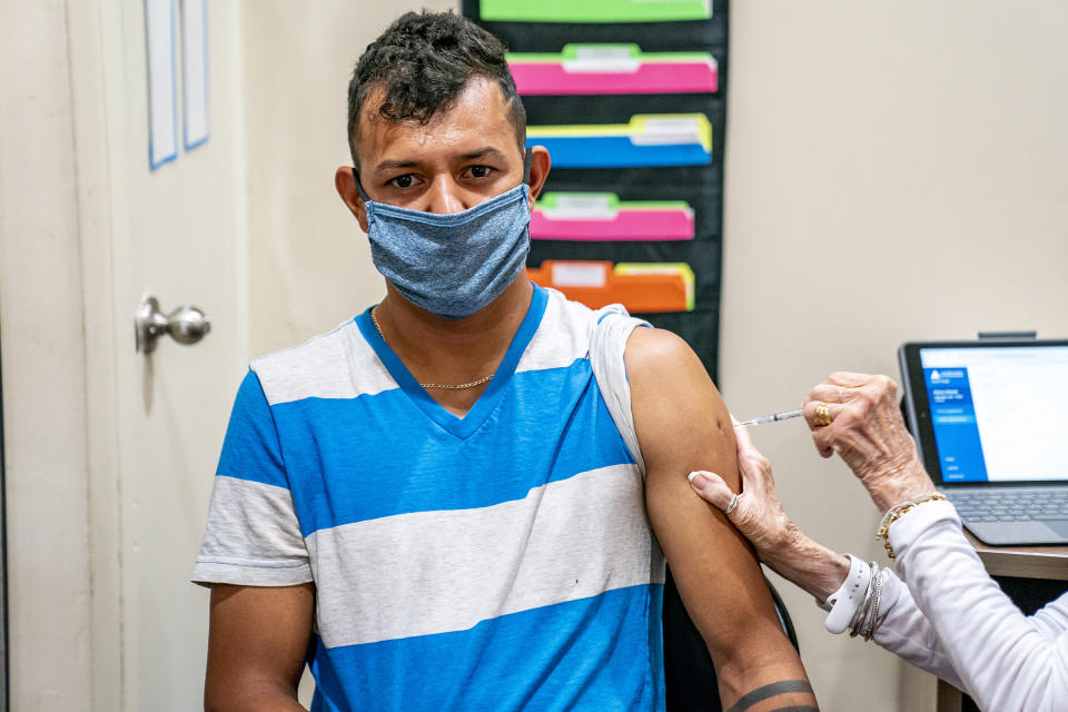 Juan Rios, of Ambridge, receives a dose of the COVID-19 vaccine at a clinic run by the Allegheny County Health Department at Casa San Jose, a non-profit serving Latino immigrants, Tuesday, Sept. 14, 2021, in the Beechview neighborhood of Pittsburgh. (Alexandra Wimley/Pittsburgh Post-Gazette via AP)