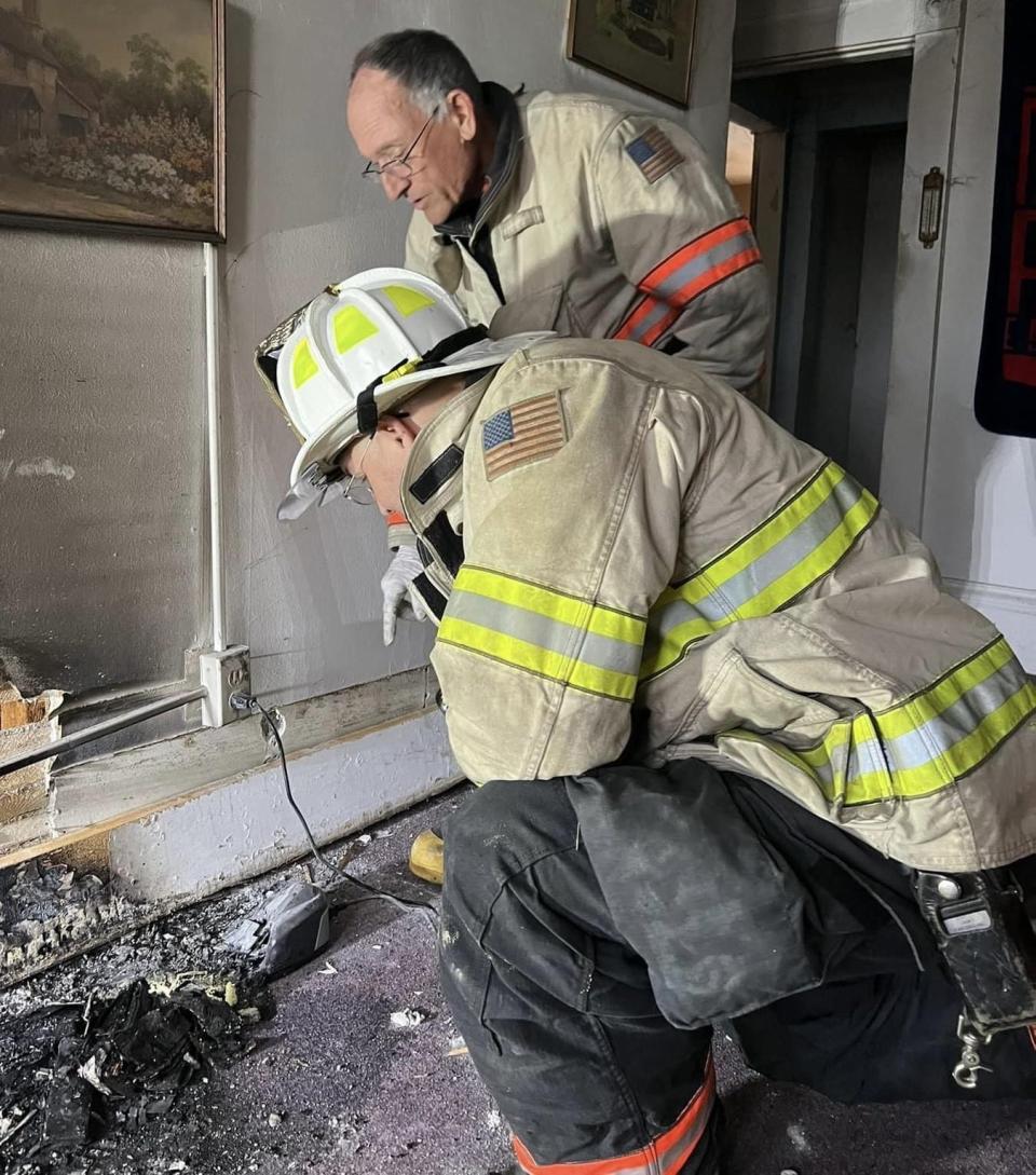 Fire officials inspect the damage of a wall that caught fire as a result of an overheated battery in an apartment on Long Sands Road in York, Maine, on April 14, 2024.