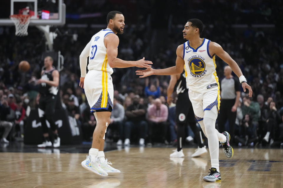 Golden State Warriors' Stephen Curry (30) celebrates his 3-point basket with Jordan Poole (3) during the first half of the team's NBA basketball game against the Los Angeles Clippers on Wednesday, March 15, 2023, in Los Angeles. (AP Photo/Jae C. Hong)