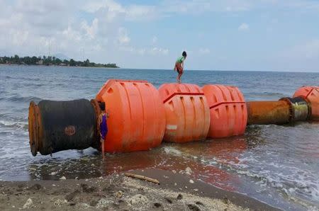 A boy standing on buoys at the shoreline of Iba, Zambales, in northern Philippines is seen in this undated photo released by the Philippine Coastguard on July 26, 2015. REUTERS/Philippine Coastguard/Handout via Reuters