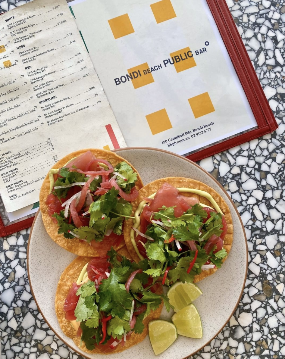 A plate of tacos and a menu at at Sydney's Bondi Beach Public Bar