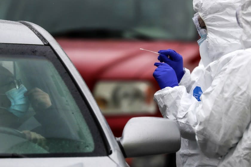 COLTON, CA - APRIL 09: Alejandra Ortiz, left, sits in her car as a nurse administers a coronavirus COVID-19 test at Arrowhead Regional Medical Center durning public testing drive-through in Colton, CA. (Irfan Khan / Los Angeles Times)