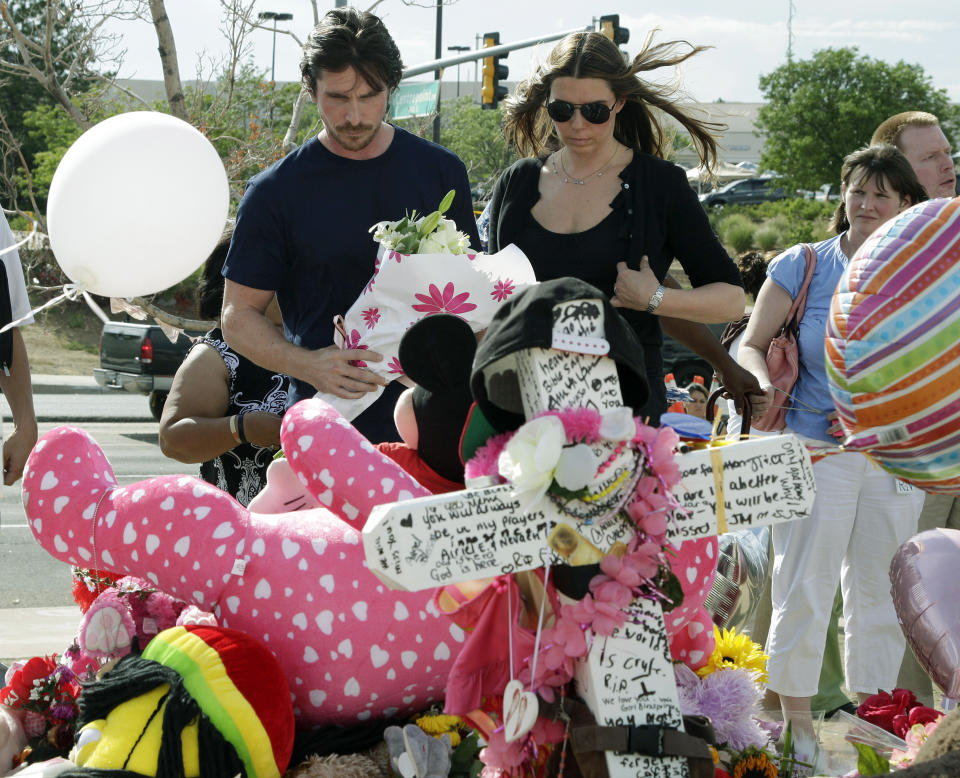 Actor Christian Bale and his wife Sibi Blazic view a cross and large display of flowers and stuffed animals dedicated to Veronica Moser-Sullivan, 6, the youngest of the 12 victims of Friday's mass shooting, Tuesday, July 24, 2012, at a memorial in Aurora, Colo. Twelve people were killed when a gunman opened fire during a late-night showing of the movie "The Dark Knight Rises," which stars Bale as Batman. (AP Photo/Ted S. Warren)