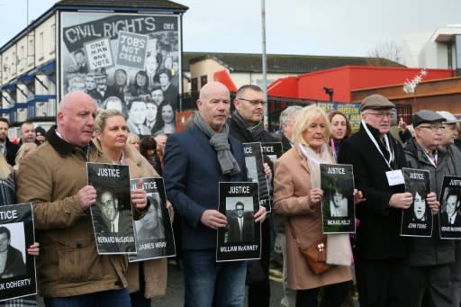 Relatives and supporters of the victims of the 1972 Bloody Sunday killings hold images of those who died as they march from the Bogside area of Derry