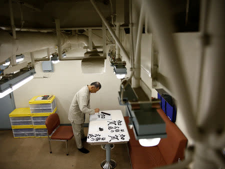 Command Master Chief Yasuharu Tohno of Japanese helicopter carrier Kaga practices calligraphy during a break from operations in the Indian Ocean, Indonesia September 24, 2018. Picture taken on September 24, 2018. REUTERS/Kim Kyung-Hoon