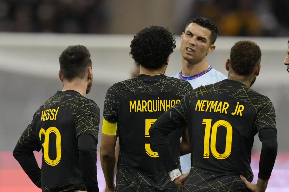 Cristiano Ronaldo hace una mueca jugando para un XI combinado de los equipos de Arabia Saudita Al Nassr y Al Hilal está flanqueado por Lionel Messi del PSG y sus compañeros de equipo Neymar y Marquinhos durante un partido amistoso de fútbol, ​​en el Estadio de la Universidad King Saud, en Riyadh, Arabia Saudita, el jueves. 19 de enero de 2023. (Foto AP/Hussein Malla)