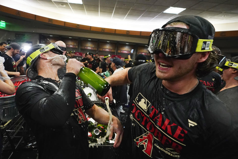 Arizona Diamondbacks players celebrate in the locker room after clinching a Wild Card spot in the MLB playoffs after a baseball game against the Houston Astros, Saturday, Sept. 30, 2023, in Phoenix. The Astros won 1-0. (AP Photo/Ross D. Franklin)