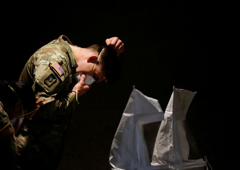 U.S. Army soldiers test the fit of N95 masks at a military field hospital for non-coronavirus patients inside CenturyLink Field Event Center during the coronavirus disease (COVID-19) outbreak in Seattle