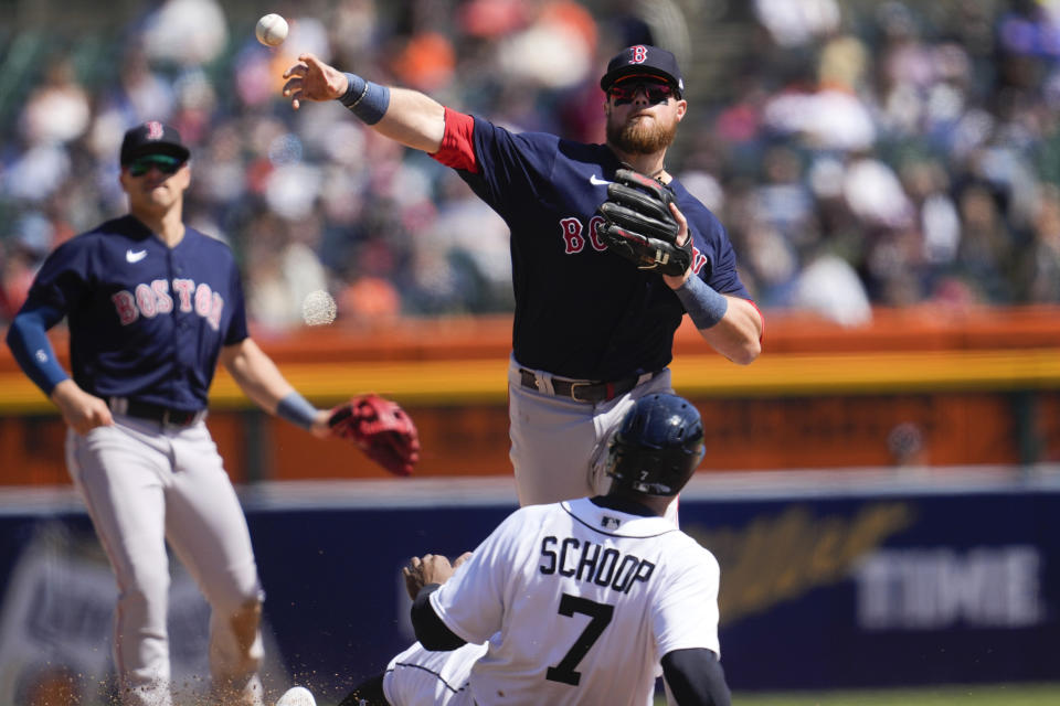 Boston Red Sox second baseman Christian Arroyo throw to first base to complete a double play as Detroit Tigers' Jonathan Schoop (7) slides late into second base in the fifth inning of a baseball game in Detroit, Sunday, April 9, 2023. (AP Photo/Paul Sancya)
