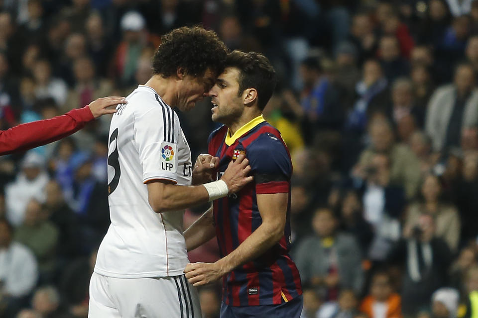 Real's Pepe, left, reacts with Barcelona's Cesc Fabregas, right, as Fabregas celebrated Lionel Messi's goal, during a Spanish La Liga soccer match between Real Madrid and FC Barcelona at the Santiago Bernabeu stadium in Madrid, Spain, Sunday, March 23, 2014. (AP Photo/Andres Kudacki)