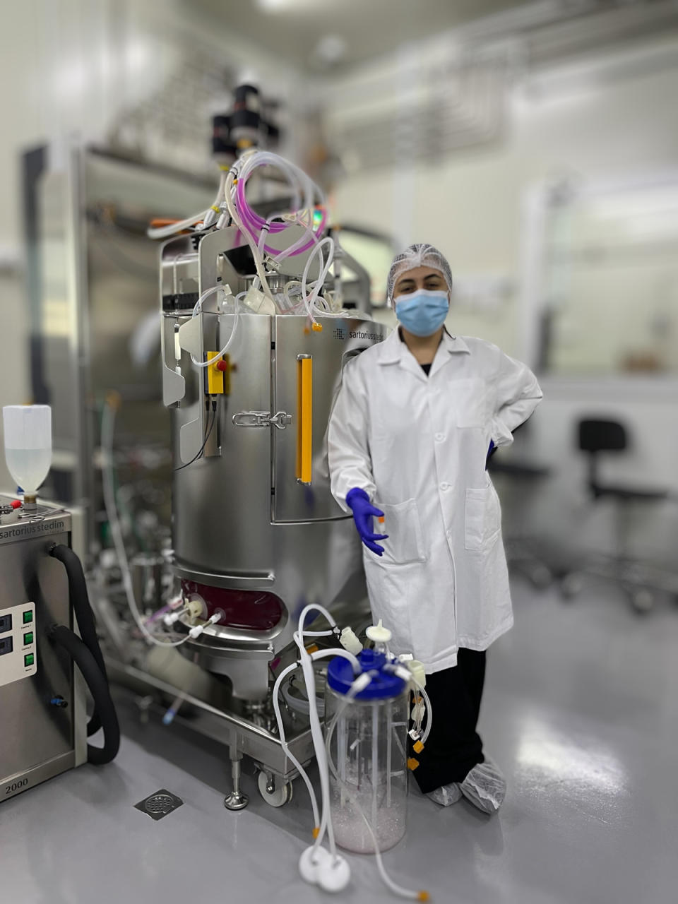 lab worker showing vial of cultivated cells