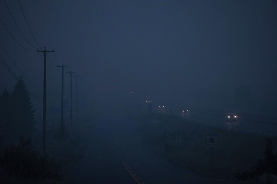 Thick smoke from wildfires burning in the area hangs in the air as motorists travel on the Trans-Canada Highway east of Kamloops, British Columbia, on Aug. 20, 2023. (Darryl Dyck/The Canadian Press via AP)