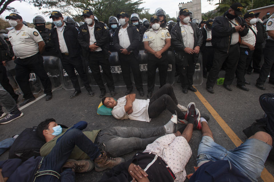 Guatemalan police agents block part of a Honduran migrant caravan in their bid to reach the U.S. border, in Vado Hondo, Guatemala, Sunday, Jan. 17, 2021. (AP Photo/Sandra Sebastian)