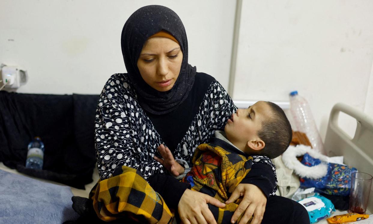 <span>A mother comforts her child, who is being treated for malnutrition at al-Awda hospital.</span><span>Photograph: Mohammed Salem/Reuters</span>